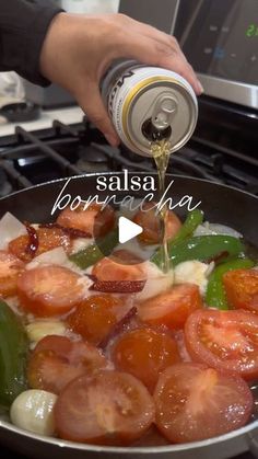 someone is pouring something into a skillet with tomatoes and peppers in it on the stove