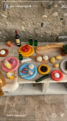 a table topped with lots of different types of food next to bottles and wine glasses