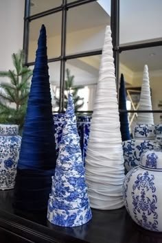 many blue and white vases are sitting on a shelf in front of a mirror