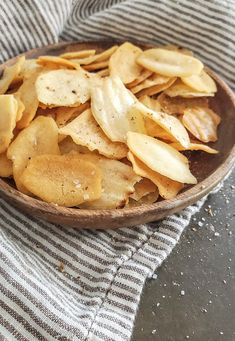 a wooden bowl filled with potato chips on top of a table