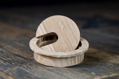 a wooden ring holder on top of a wooden table