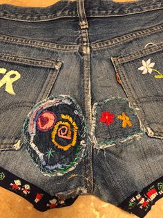 Embroidered Dark Wash Denim Bottoms, Hippie Denim Blue Bottoms, Vintage Floral Embroidered Bottoms For Summer, Embroidered Dark Wash Cotton Bottoms, Embroidered Dark Wash Bottoms For Summer, Embroidered Cotton Jean Shorts, Dark Wash Embroidered Cotton Bottoms, Dark Wash Embroidered Bottoms For Summer, Festival Dark Wash Cotton Bottoms