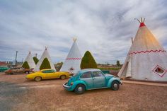 three cars are parked in front of teepees