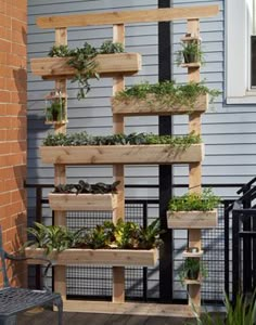 an outdoor planter made out of wooden pallets with plants growing in them on the side of a house