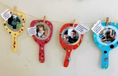 three photo frames hanging from clothes pins on a line with clothes pins attached to them