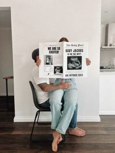 a man sitting in a chair holding up a sign