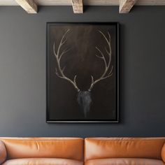 a deer's head hangs on the wall above a leather couch