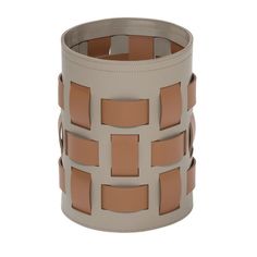 a white and tan leather cuff with squares on the inside, in front of a white background