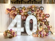 the number forty is surrounded by balloons and flowers