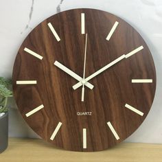 a wooden clock sitting next to a potted plant