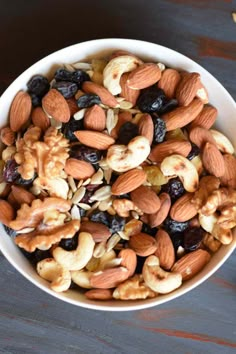 a white bowl filled with nuts and raisins