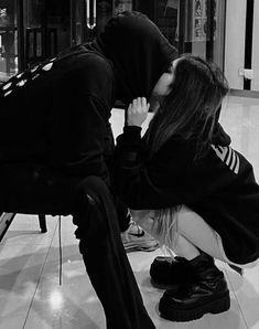 two people sitting on the floor kissing each other