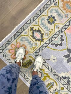 a person standing on top of a colorful rug