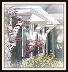 an image of a house with flowers in the foreground and bushes on the other side