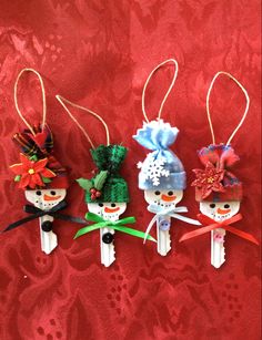 three small ornaments are hanging from clothes pins on a red background with flowers and leaves