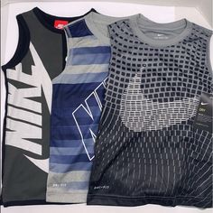 Brand New With Tags Boys Youth Size 6 Nike Tank Top Set Of 3 Dri-Fit Soft Athletic Active Material Don't Wrinkle Easy To Clean Quick Drying Gray Sporty Tops For Playwear, Nike Summer Gray Tops, Nike Gray Summer Tops, Black Crew Neck Tops For Playwear, Nike Gray Cotton Tops, Nike Gray Sports Top, Gray Nike Sports Top, Nike Gray Sporty Top, Casual Black Playwear Tops