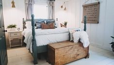 a bed room with a neatly made bed and a wooden trunk on the floor next to it