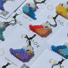 cross stitch keychains with colorful birds on them