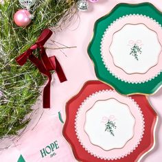 three plates with christmas designs on them sitting next to a wreath and ornament