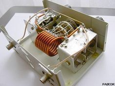 an electronic device with many wires attached to the back of it's enclosure, on top of a white surface