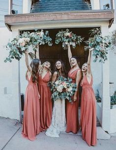 the bridesmaids are holding their bouquets high in the air