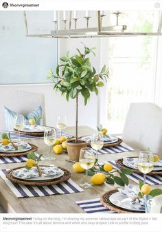 the table is set with plates, glasses and lemons on it for a meal