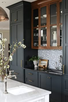 a kitchen with black cabinets and white counter tops