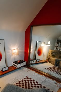 a room with red walls and white rugs in front of a large mirror on the floor