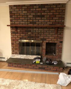 a living room with a fire place and rugs on the floor in front of it