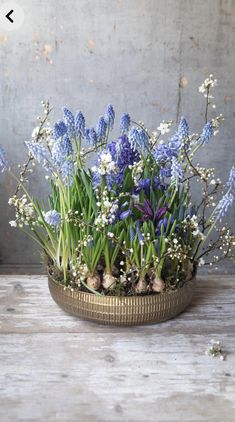 blue and white flowers in a basket on a table