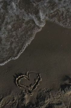 the heart is drawn in the sand at the beach