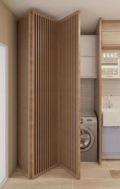 an open door to a washer and dryer in a room with wood paneling