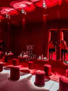 a room with red lighting and lots of stools on the floor that have words written on them