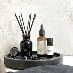 an assortment of essentials on a tray next to a candle and some other items