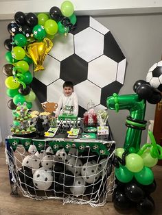 a table topped with balloons and soccer balls