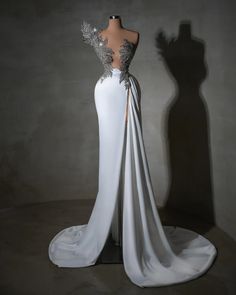 the back of a white wedding dress with silver appliques on it's shoulders