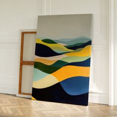 an abstract painting on the wall next to a wooden frame in a room with white walls and parquet flooring