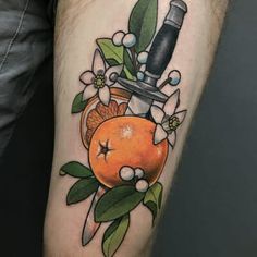 a tattoo with an orange and a knife on it's arm, surrounded by flowers