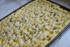 an uncooked casserole with cheese and herbs