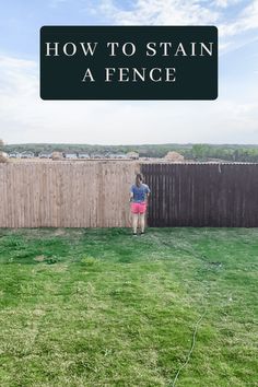 a person standing in the grass near a fence with text overlay that reads how to stain a fence