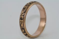 a wedding ring with an intricate design on the inside and outside, sitting on a white surface