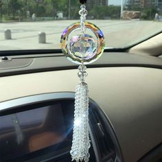 a car dashboard hanging from the side of it's dash with a crystal ball and beaded tassel