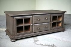 a wooden entertainment center sitting on top of a cement floor