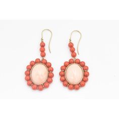 This is part of Chairish’s Fine Jewelry assortment.  These earrings feature a large oval cabochon angel skin coral piece measuring approximately  .80" x .60" set in a frame of orange coral beads measuring approximately 5.5 mm each.  The earrings dangle off an 18k yellow gold wire.  Pierced ears are required to wear these. Coral Oval Jewelry For Gifts, Oval Coral Jewelry For Gift, Orange Oval Cabochon Jewelry For Formal Occasions, Formal Orange Oval Cabochon Jewelry, Vintage Oval Coral Jewelry, Vintage Coral Oval Jewelry, Formal Coral Jewelry With Cabochon Details, Formal Coral Jewelry With Cabochon, Elegant Orange Earrings With Natural Stones