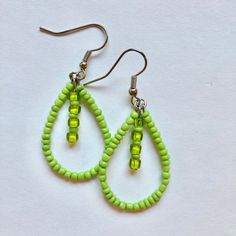 green beaded earrings on white background