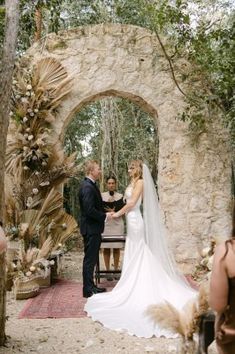 a bride and groom standing in front of an archway at the end of their wedding ceremony