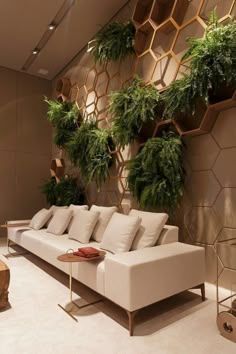 a living room filled with furniture and lots of greenery on the wall behind it