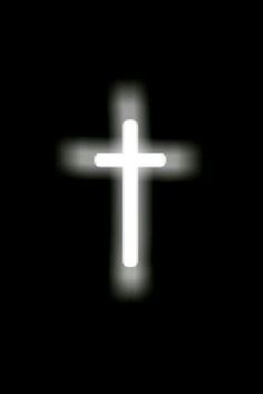 a white cross is glowing in the dark