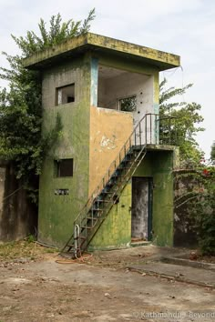 an old run down building with stairs leading up to it