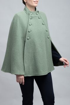 Meet the Margaret Cape: Crafted from 100% virgin wool, this elegant cape combines classic style with modern sophistication. It features a defined collar, a double-breasted front with fabric-covered buttons, and flowing bell sleeves for a dramatic flair. Ideal for transitioning from day to evening, the Margaret Cape offers warmth, comfort, and a polished look that captures timeless elegance. Perfect for anyone seeking a chic, functional wardrobe staple. Elegant Cape, Functional Wardrobe, Cape Designs, Cashmere Cape, Green Sage, Pink October, Wool Cape, Capes For Women, Vest Blazer